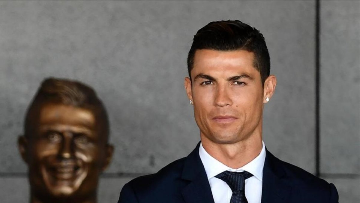 Cristiano Ronaldo en Madeira, junto al busto que le realizaron en su país.-AFP / FRANCISCO LEONG