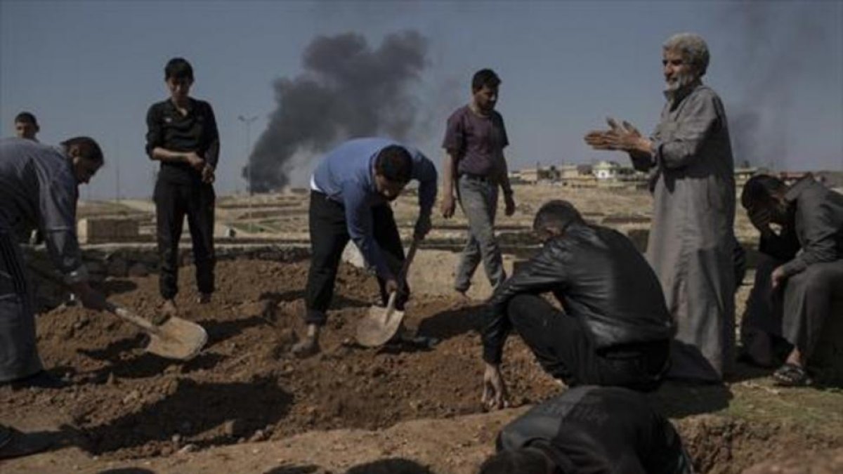 Unos civiles entierran cadáveres en el lado occidental de Mosul.-AP