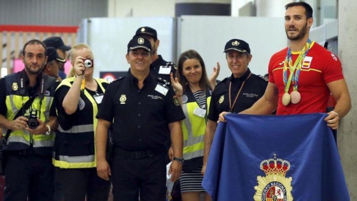 Craviotto, con sus dos medallas y la bandera de la Policía Nacional.-EFE / MARISCAL