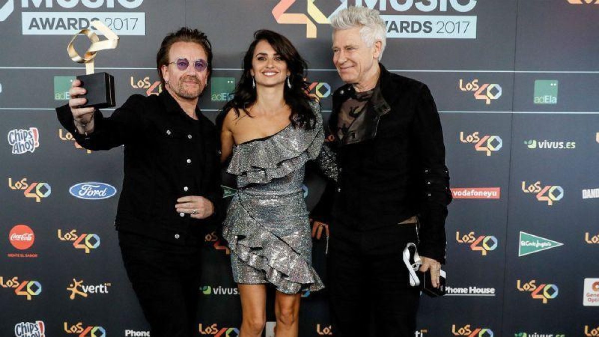 El cantante Bono y el bajista Adam Clayton, junto a Penélope Cruz, en los Premios de Música Los 40.-EFE / EMILIO NARANJO