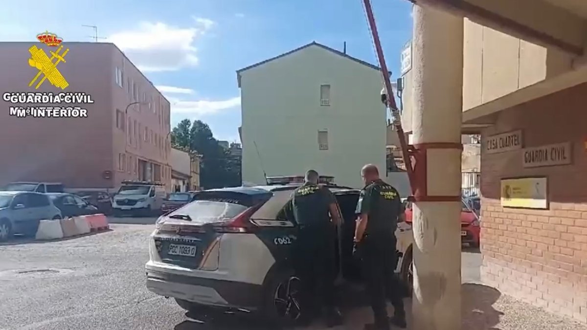 Agentes de la Guardia Civil meten al detenido en el coche oficial.