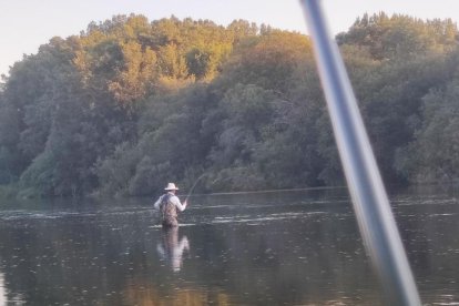 Un pescador de trucha prueba fortuna en un coto en el verano de 2023.