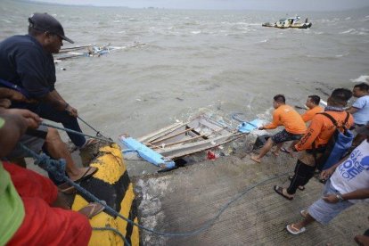 Miembros de la Guardia Costera de Filipinas transportan los restos de un barco.-EPA