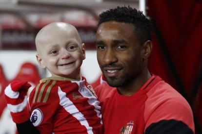 Jermain Defoe, delantero del Sunderland, sostiene en brazos a Bradley Lowery.-REUTERS