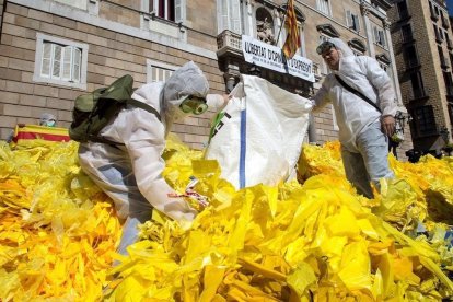 La brigada Els Segadors del Maresme vuelva miles de lazos amarillos arrancados frente al Palau de la Generalitat.-EFE