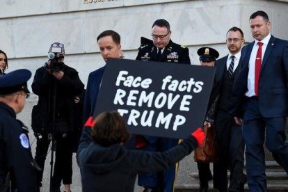 Una mujer protesta contra Trump a las puerta del Congreso a la salida del asesor de seguridad nacional Alexander Vindman, el pasado 19 de noviembre.-AFP