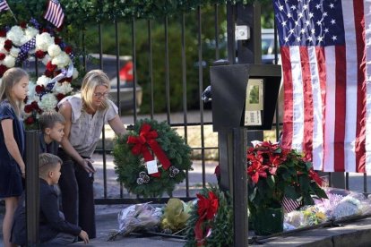 Tiffany Utterson y sus hijos Ella, Ian y Owen depositan una corona de flores en la puerta exterior de la residencia del expresidente George Bush, en Houston (Tejas) el 2 de diciembre del 2018. /-AP / DAVID J. PHILLIP