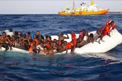 Momento en que varios inmigrantes son rescatados el lunes en alta mar cerca de la costa italiana.-ONG SOS MEDITERRANEE