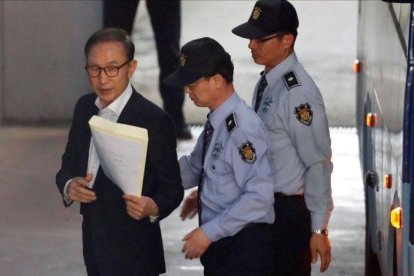 Imagen de archivo del expresidente surcoreano Lee Myung-bak mientras es escoltado por policías en la sala de un tribunal en Seúl.-EFE / JEON HEON-KYUN