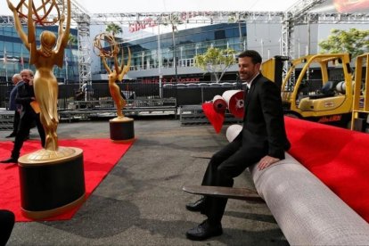 El presentador de la gala, Jimmy Kimmel, posa para la prensa, sentado sobre la alfombra roja de los 68º premios Emmy, aún enrollada.-MARIO ANZUONI / REUTERS