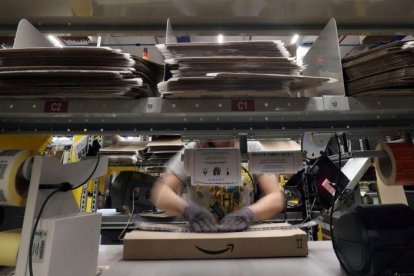 Un trabajador prepara un pedido en una caja de Amazon.-REUTERS / ALBERT GEA