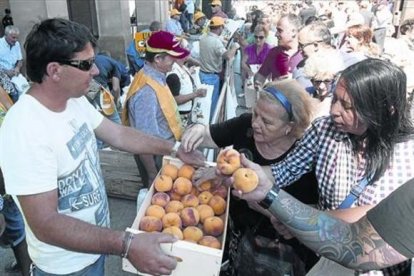 Agricultores reparten melocotones en una protesta del sector en Zaragoza.-EFE / TONI GALÁN