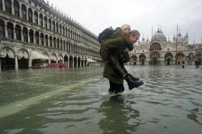 Una pareja cruza la plaza San Marcos.-EFE /EPA ANDREA MEROLA