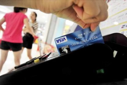 Una mujer usa su tarjeta de crédito.-AFP/FRANKO LEE