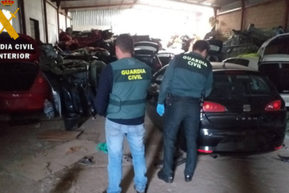 La Guardia Civil analiza los vehículos en el interior de la nave donde presuntamente se operaba un taller sin ningún permiso. HDS