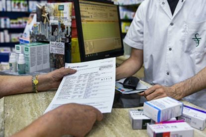 Compra de medicamentos con receta en una farmacia.-JORDI COTRINA