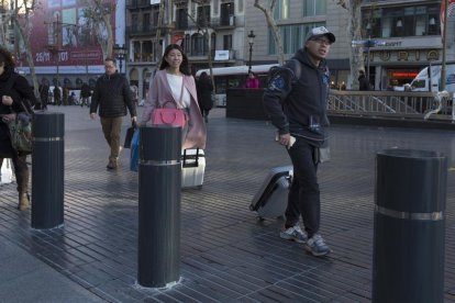 Bolardos situados en la entrada a la Rambla después de los atentados.-ALBERT BERTRAN