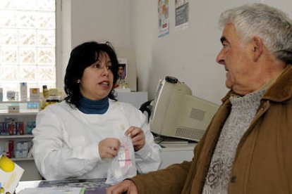 Francisca Castro Corada, Kika, atendiendo a un cliente en su farmacia de Matamala de Almazán. / VALENTÍN GUISANDE-