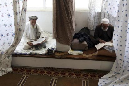 Musulmanes afganos leen versos del Corán en una mezquita de la ciudad de Kabul. /-AP