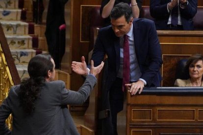 Pablo Iglesias, saluda al presidente del gobierno en funciones Pedro Sánchez , tras su intervención este martes en el Congreso.-DAVID CASTRO