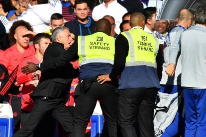 Una muralla de seguratas frena la ira de Mourinho en Satmford Bridge.-EL PERIÓDICO