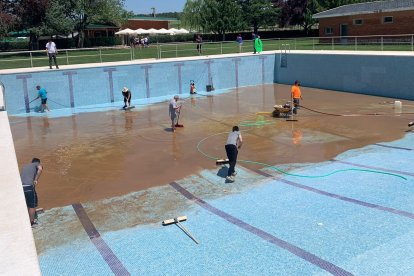 Voluntarios limpiando la piscina de Bayubas.-HDS