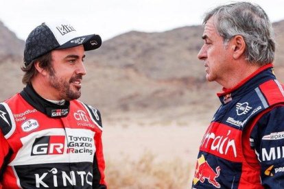 Fernando Alonso y Carlos Sainz conversan tras finalizar la etapa de hoy en el Dakar.-DPPI / FREDERIC LE FLOCH