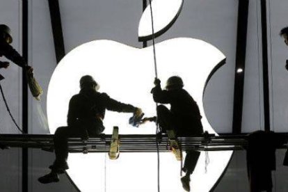 Operarios colocan un logo de Apple en una de las sedes de la compañía.-Foto: REUTERS