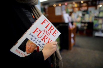 Una mujer sostiene un ejemplar de Fire and Fury, en una librería de Washington (EEUU).-CARLOS BARRIA (REUTERS)