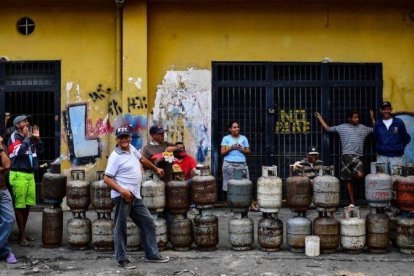 Ciudadanos hacen cola para para reemplazar los bidones de gas propano vacíos en el barrio Las Minas de Baruta, en Caracas.-RONALDO SCHEMIDT (AFP)