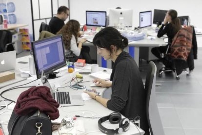 Trabajadores en una oficina frente al ordenador.-FERRAN NADEU