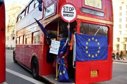 Un activista anti-brexit muestra una bandera de la UE en un autobús de Londres.-AFP / BEN STANSALL