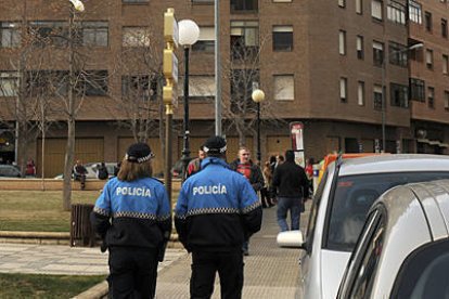 Varios policías caminan frente a una farola en la zona de Los Pajaritos. / VALENTÍN GUISANDE-