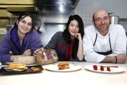 Las alumnas del Basque Culinary Center de San Sebastián, María y Yao Yao, preparan en el restaurante Cocinandos de León, bocadillos con queso artesanal Los Payuelos. Junto a ellas, el chef y propietario del restaurante, Juanjo Pérez-Carlos S. Campillo / ICAL