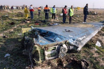 Técnicos supervisan el escenario donde explotó el avión ucraniano tras ser atacado por error por un misil iraní.-AFP / AKBAR TAVAKOLI