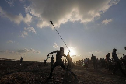 Un manifestante lanza una piedra con su honda durante unos disturbios en la frontera con Israel tras los rezos del Viernes, en Gaza, Cisjordania.-EFE