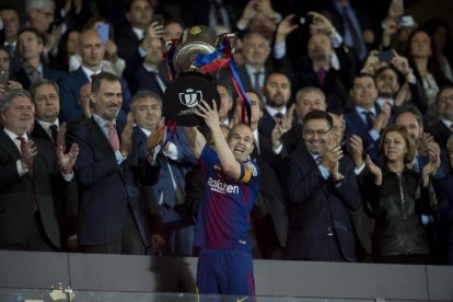 Iniesta recoge la copa del ganador durante la final de la Copa del Rey.-JORDI COTRINA