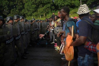 Elementos de la Guardia Nacional, policías federales y personal del Instituto Nacional de Migración (INM) detienen la marcha de unos 2.000 migrantes.-EFE