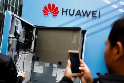 Un usuario toma una foto del interior de una máquina en el estand de Huawei en una feria celebrada en la ciudad china de Shenzhen.-THOMAS PETER (REUTERS)