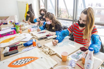 Participantes en ‘Píntate el toto’ decoran sus bolsas tras el coloquio sobre sexualidad femenina. MARIO TEJEDOR