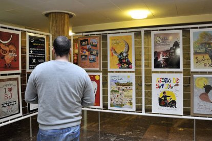 Un ciudadano observa los carteles de San Juan que se exhiben en el patio de columnas del Ayuntamiento. / REPORTAJE GRÁFICO: VALENTÍN GUISANDE-