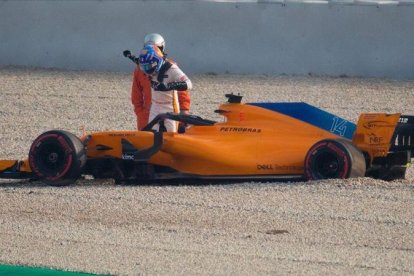 Alonso sale del coche en Montmeló tras perder una rueda.-EFE / ENRIC FONTCUBERTA