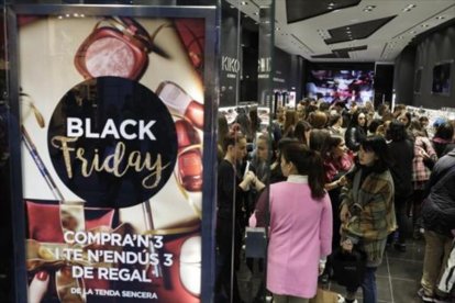 Dos mujeres cargan las bolsas con las compras realizadas el Black Friday .-FERRAN NADEU