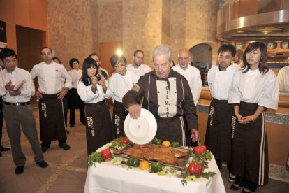 Gil Martínez trocea el cochinillo con un plato. / JUNTA-