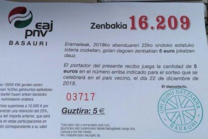 Participación de un cuarto de décimo de la lotería de Navidad emitida para el sorteo de este año por la sede del PNV en Basauri (Vizcaya). En el aviso central, la indicación de que se trata de lotería del país vecino.-G.E.