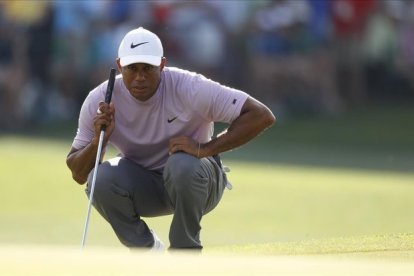 Tiger Woods observa una línea de putt en la tercera jornada.-JUSTIN LANES (EFE)