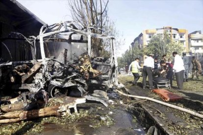 Rescate de víctimas entre los restos calcinados del autobús atacado en Kabul-EFE / HEDAYATULLAH AMID