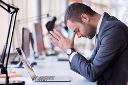 Un chico en la oficina sin poder trabajar.-123RF