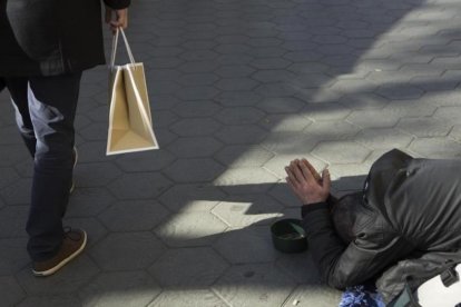 Contraste entre pobreza y poder adquisitivo en el Paseo de Gracia, de Barcelona.-