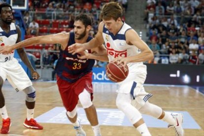 Doncic conduce el balón presionado por el azulgrana Perperoglou en un reciente Barça-Madrid-EFE / DAVID AGUILAR